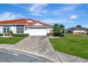 House exterior showcasing a paved driveway and lush landscaping at 741 Fairway Ridge Ct, Sun City Center, FL 33573