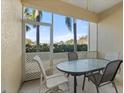 Relaxing screened porch with table and chairs, overlooking a lush landscape at 8003 Limestone Ln # 15-103, Sarasota, FL 34233