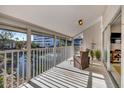 Spacious screened balcony overlooking a pond with comfortable wicker furniture at 1130 W Peppertree Ln # 118, Sarasota, FL 34242