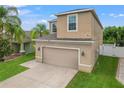 Two-story house with beige exterior, two-car garage, and well-maintained lawn at 1964 Hawks View Dr, Ruskin, FL 33570