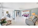 Spacious living room with terrazzo floors flows into a sunroom with lake views at 2271 Sandlewood Dr, Venice, FL 34293