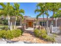 Charming home featuring a brick pathway, tiled roof, well-manicured landscaping, and mature trees at 2605 Desoto Rd, Sarasota, FL 34234