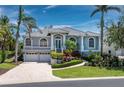 Charming home featuring beautiful landscaping, arched windows and a brick paved driveway at 3260 Bayou Rd, Longboat Key, FL 34228