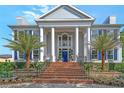 Elegant home featuring a grand entrance with stately columns, brick steps, and beautiful landscaping with mature palm trees at 1541 Bay Point Dr, Sarasota, FL 34236
