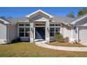 Charming single-story home featuring a neatly maintained lawn and a welcoming blue front door at 2155 Jagust Rd, North Port, FL 34288