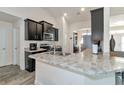 Open kitchen featuring dark cabinetry, stainless appliances, and a marbled countertop island at 2155 Jagust Rd, North Port, FL 34288
