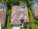 Aerial view of a home featuring a tile roof, screened-in pool, and beautifully landscaped backyard at 2737 Harvest Dr, Sarasota, FL 34240