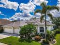 Beautiful one-story residence with a three-car garage, lush landscaping, and a welcoming front entrance at 2737 Harvest Dr, Sarasota, FL 34240