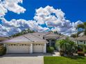 Charming single-story home with a well-manicured lawn, three-car garage, and elegant architectural details at 2737 Harvest Dr, Sarasota, FL 34240