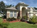 Charming home exterior with manicured landscaping, stone accents, and an inviting arched entryway at 3439 101St E Ave, Parrish, FL 34219