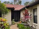 Inviting home entrance with terracotta tile roof and lush, well-maintained landscaping at 7207 Oak Moss Dr # 63, Sarasota, FL 34241