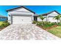House exterior showcasing a two-car garage and well-maintained landscaping at 9244 Ballaster Pointe Loop, Parrish, FL 34219