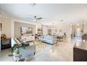 Open-concept living space featuring two sofas, a media center, and a dining area with an elegant chandelier at 10379 Medjool Dr, Venice, FL 34293