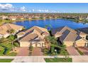 An aerial view showcases beautiful homes and a tranquil lake reflecting the surrounding community at 21620 Avon Park Ct, Venice, FL 34293