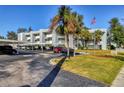 Condominium exterior showing parking, landscaping, flag, and balconies at 3300 S Beneva Rd # 224, Sarasota, FL 34232