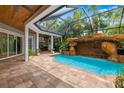 Inviting screened pool area with rock waterfall feature and outdoor grilling space, perfect for entertaining at 1810 Lincoln Dr, Sarasota, FL 34236