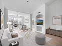 Open living room with white walls, hardwood floors, bright sunlight, a stylish white couch and elegant decor at 4152 Central Sarasota Pkwy # 727, Sarasota, FL 34238