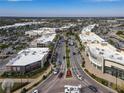 Aerial view of a commercial district with shops, restaurants, and a busy street with palm trees at 5697 Sheffield Greene Cir # 51, Sarasota, FL 34235