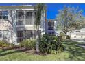 A condominium exterior shows well-manicured landscaping and the building's architecture and screened lanai at 5697 Sheffield Greene Cir # 51, Sarasota, FL 34235