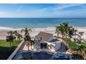 Overhead view of the beach pavilion on pristine white sands with serene blue waters providing a perfect beachfront experience at 605 Sutton Pl # 205, Longboat Key, FL 34228