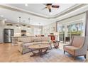 Open-concept living room with a comfortable sofa, natural light, a ceiling fan and seamless kitchen access at 11422 Griffith Park Ter, Bradenton, FL 34211
