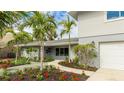 Beautifully landscaped home featuring fresh flowers and healthy young palm trees at 3348 S Seclusion Dr, Sarasota, FL 34239