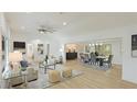 Bright living room with modern decor, wood floors, and an open floor plan to the dining area at 3348 S Seclusion Dr, Sarasota, FL 34239
