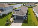 A beautiful home featuring a brick driveway, lush green lawn, and a serene lake view in the neighborhood at 4514 Big Woods Way, Parrish, FL 34219