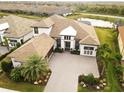 An aerial view shows a beautiful two-story home with tile roof, a large yard and a lake view at 5305 Brookgrove Dr, Sarasota, FL 34238