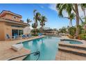 Private pool and jacuzzi with waterfront views, palm trees, and blue lounge furniture at 5376 Shadow Lawn Dr, Sarasota, FL 34242