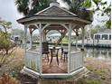 Cozy gazebo with a table and chairs overlooking the waterfront, a perfect spot for relaxation at 5402 Shadow Lawn Dr, Sarasota, FL 34242
