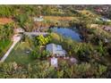 Charming home aerial with a private pond, lush landscaping, and beautiful surrounding countryside at 5645 Churchill Downs Rd, Sarasota, FL 34241