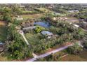 Picturesque aerial view showcasing a home with a private pond, surrounded by trees and green space at 5645 Churchill Downs Rd, Sarasota, FL 34241