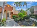 Exterior view of a multi-story condo unit with tropical landscaping and sunny sky at 144 Wild Palm Dr, Bradenton, FL 34210