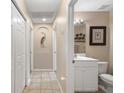 Bright hallway features neutral walls with an artistic arched nook and connects to an adjacent bathroom at 1577 Taggard Rd, North Port, FL 34288