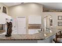 Kitchen boasts granite countertops and white cabinets, accented with an alligator sculpture at 1577 Taggard Rd, North Port, FL 34288