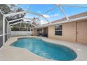 Inviting in-ground pool in a screened enclosure, surrounded by a concrete patio perfect for relaxation at 1577 Taggard Rd, North Port, FL 34288