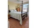 Cozy main bedroom features a four-poster bed, vintage decor, and a sunny window view at 2601 Gulf N Dr # B16, Bradenton Beach, FL 34217