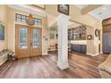 Grand foyer featuring wood floors, decorative columns, and a beautiful chandelier at 603 Harbor Shore Dr, Nokomis, FL 34275