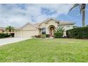 Inviting single-story home featuring a well-manicured lawn, arched entryway, and attached two-car garage at 644 Rivendell Blvd, Osprey, FL 34229
