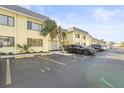 A two-story condo building with light yellow paint, grey roof, and a parking lot at 6703 Midnight Pass Rd # 108B, Sarasota, FL 34242