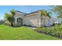 Beautifully landscaped single-Gathering home showcasing lush greenery and a well-maintained lawn at 7668 Registrar Way, Sarasota, FL 34243