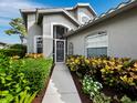 Attractive home showcasing a screened entryway, manicured landscaping, and a well-maintained walkway at 8737 Pebble Creek Ln, Sarasota, FL 34238