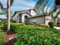 Charming single-Gathering home featuring lush landscaping and a well-maintained exterior, creating a welcoming curb appeal at 8737 Pebble Creek Ln, Sarasota, FL 34238