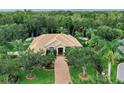 Stunning home with lush landscaping, brick driveway and neutral paint nestled in a wooded area at 11432 Savannah Lakes Dr, Parrish, FL 34219