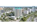 Aerial view showcasing a luxury high-rise condo with palm trees, and city streets at 340 S Palm Ave # Pl1, Sarasota, FL 34236