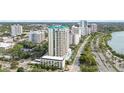 This is an aerial view of a high-rise condominium building in an urban area, surrounded by lush greenery at 340 S Palm Ave # Pl1, Sarasota, FL 34236
