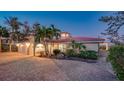 Stunning two-story home featuring a brick driveway, arched entryway, and lush tropical landscaping at 3858 Casey Key, Nokomis, FL 34275
