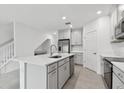 Bright kitchen with gray cabinets, stainless appliances, an island with quartz countertop, and tile flooring at 5447 Tripoli Dr, Palmetto, FL 34221