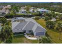 Aerial view of a charming home with a screened-in pool and waterfront access with lush landscaping at 9008 Allapata Ln, Venice, FL 34293
